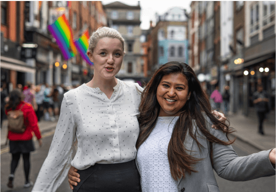 two girls in good mood  posing for a photo in the street