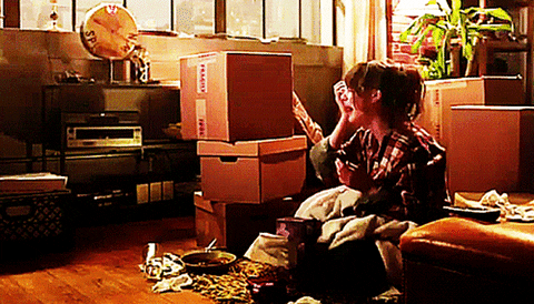 Girl crying among a pile of moving boxes